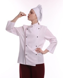 Photo of Confectioner in uniform showing delicious gesture on white background