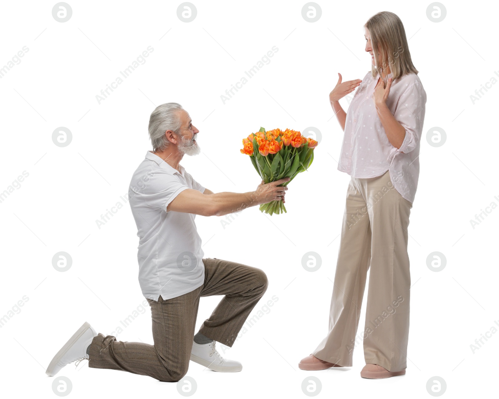 Photo of Man presenting bouquet of tulips to his happy wife on white background