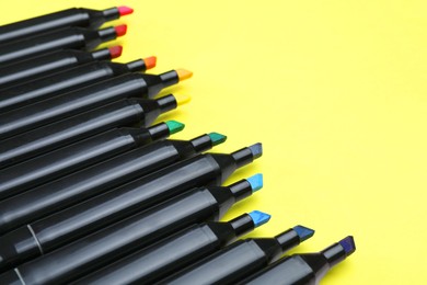 Photo of Colorful markers on yellow background, closeup. Space for text