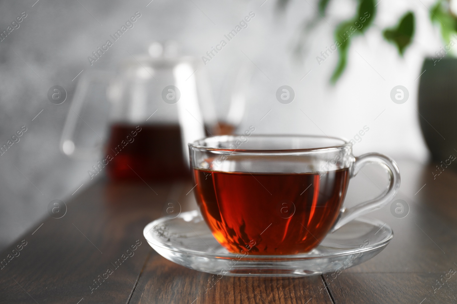 Freshly brewed tea in glass cup on wooden table, closeup Photo of Freshly brewed tea in glass cup on wooden table, closeup