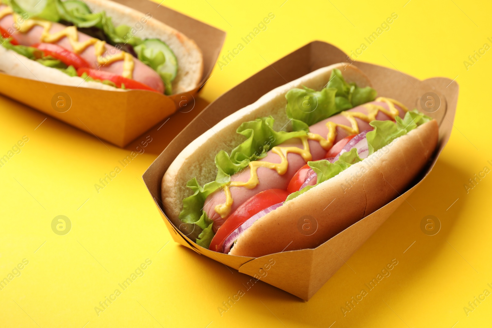 Tasty hot dogs on yellow background, closeup Photo of Tasty hot dogs on yellow background, closeup