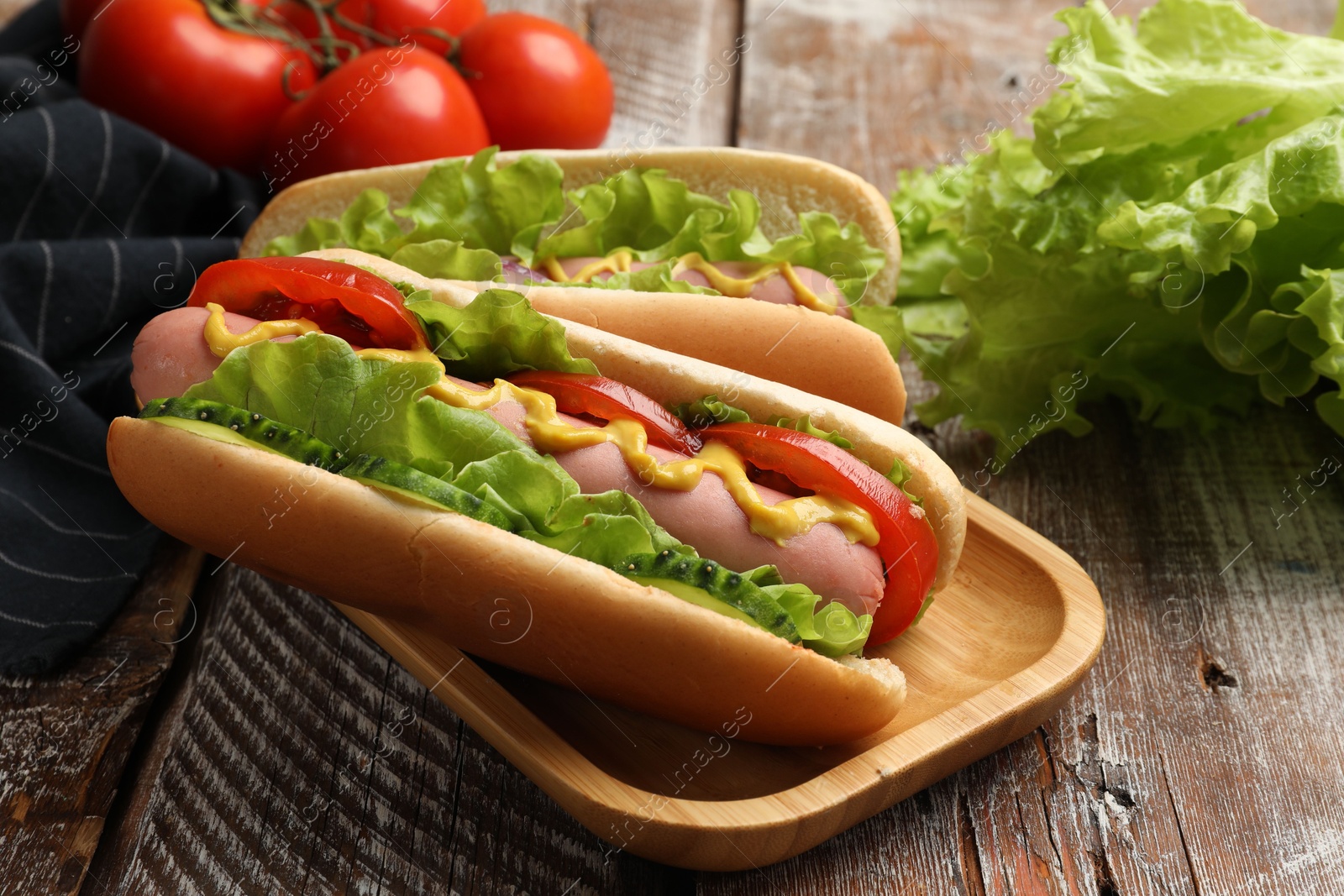 Tasty hot dogs on wooden table, closeup Photo of Tasty hot dogs on wooden table, closeup