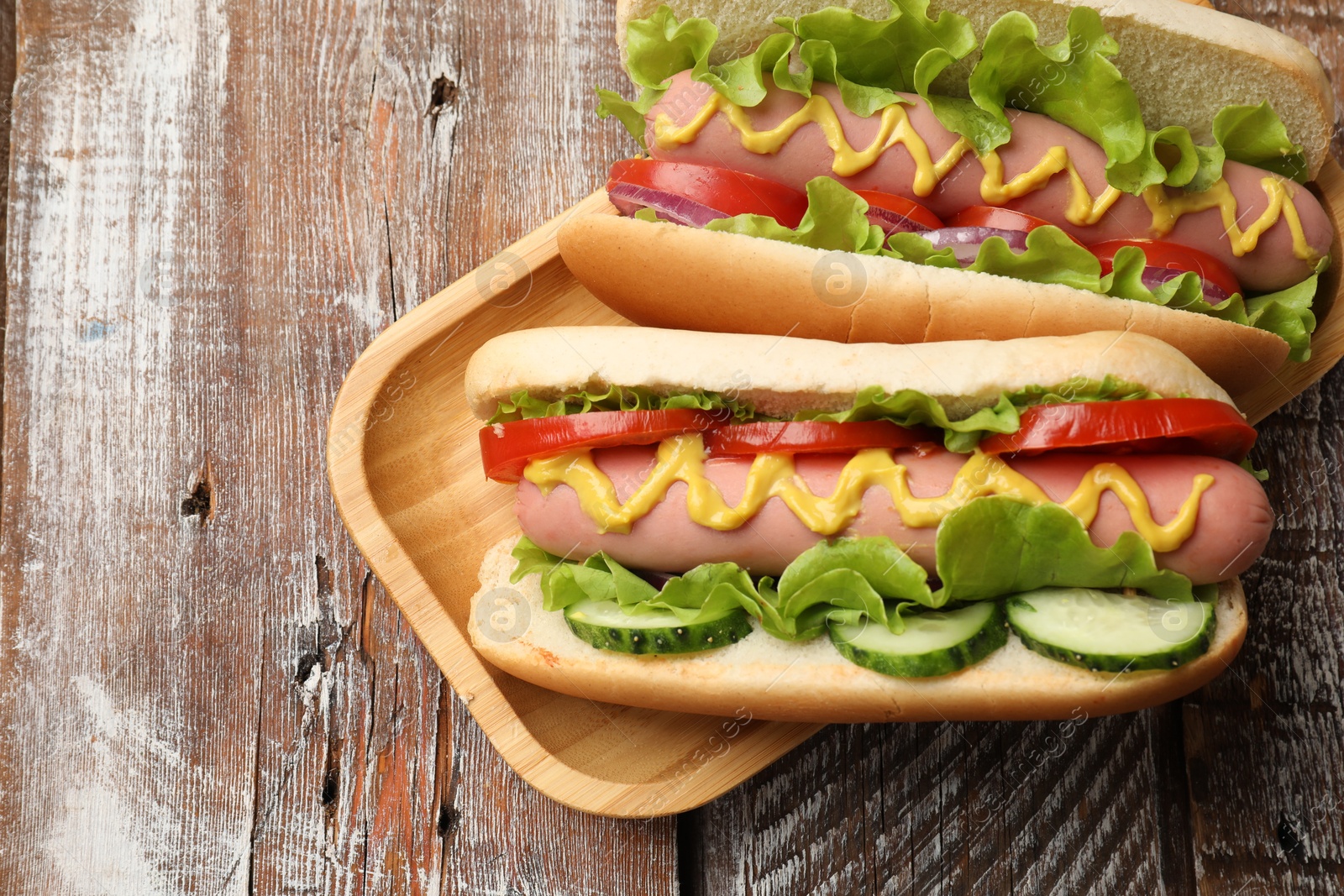 Tasty hot dogs on wooden table, top view Photo of Tasty hot dogs on wooden table, top view