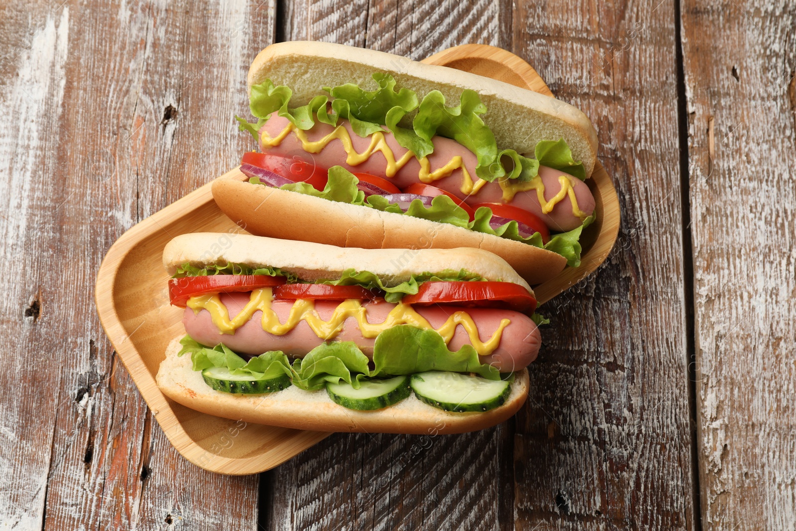 Tasty hot dogs on wooden table, top view Photo of Tasty hot dogs on wooden table, top view