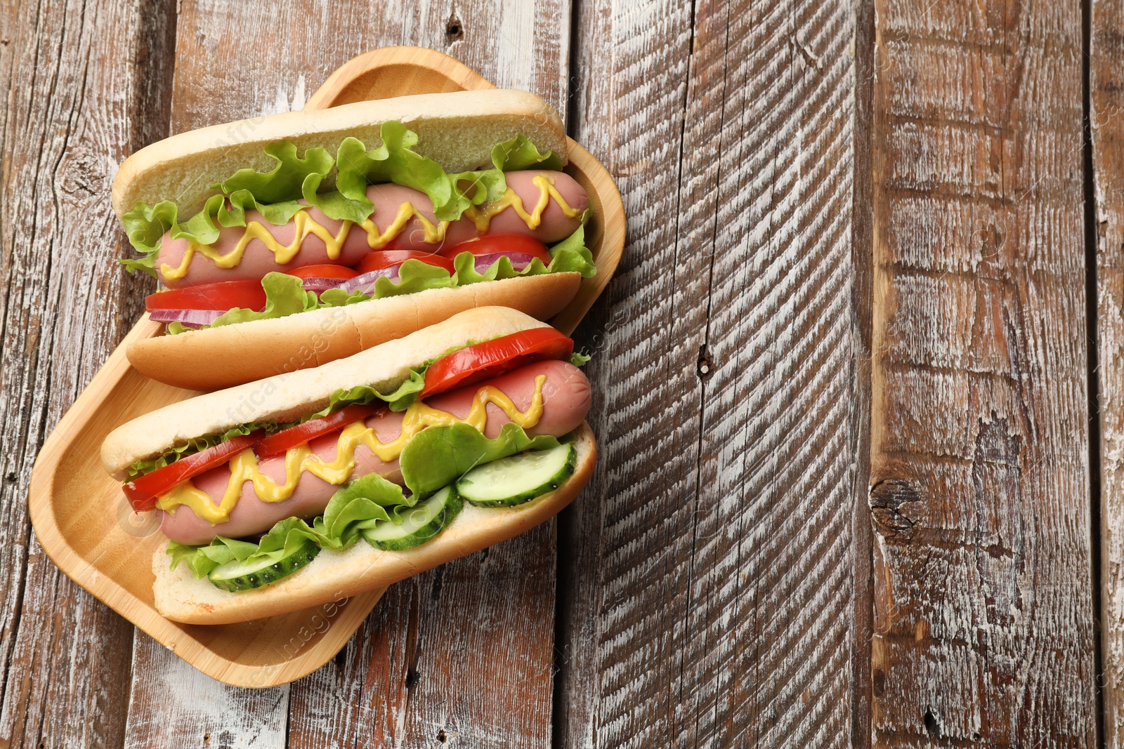 Tasty hot dogs on wooden table, top view. Space for text Photo of Tasty hot dogs on wooden table, top view. Space for text