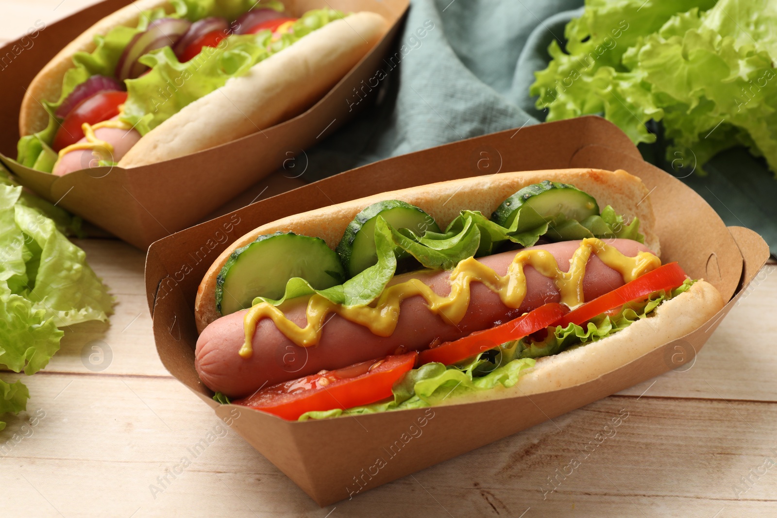 Tasty hot dogs on wooden table, closeup Photo of Tasty hot dogs on wooden table, closeup