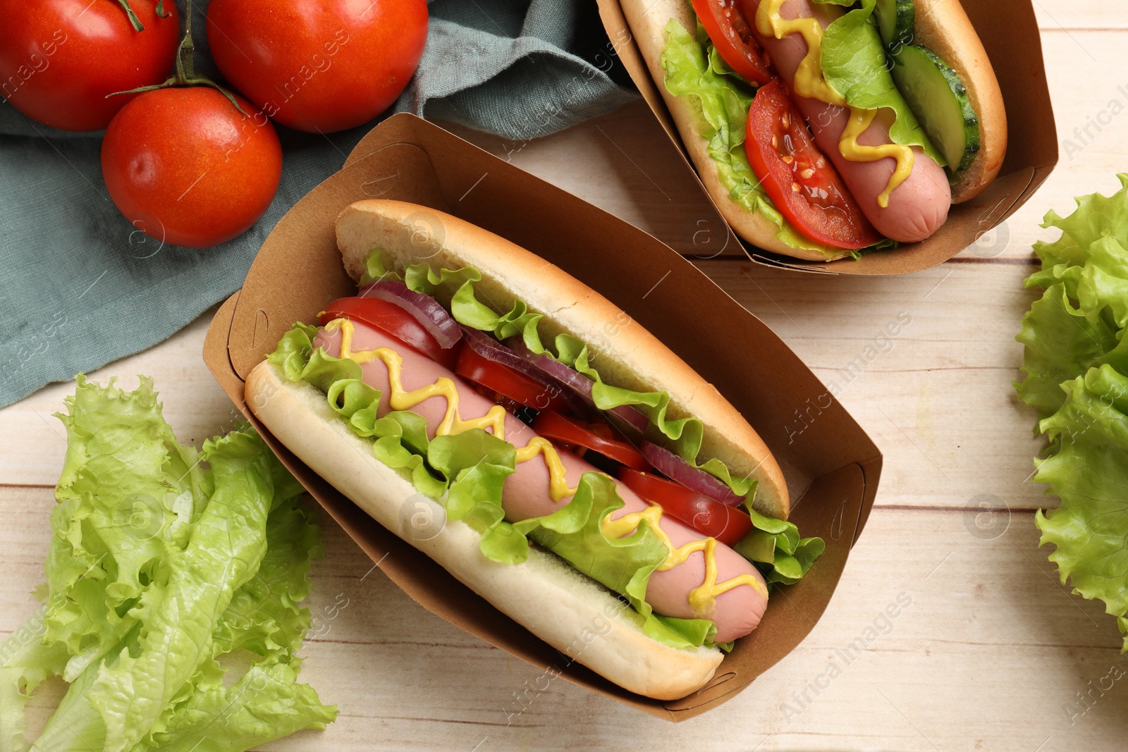 Tasty hot dogs on wooden table, flat lay Photo of Tasty hot dogs on wooden table, flat lay
