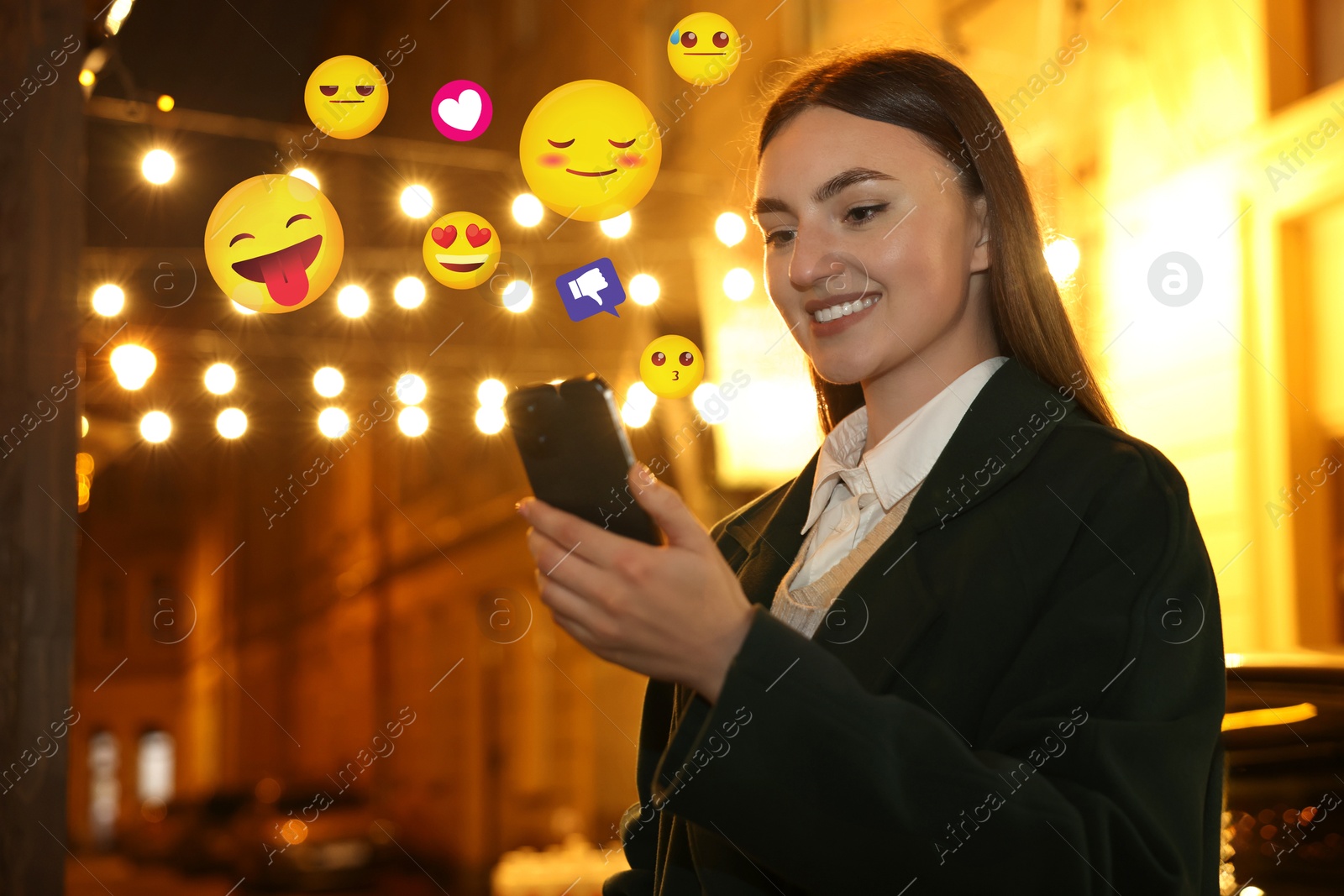 Image of Social media. Happy woman using mobile phone outdoors. Different notification signs and emojis near gadget