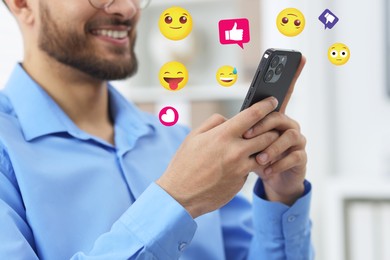 Image of Social media. Happy man using mobile phone, closeup. Different notification signs and emojis near gadget