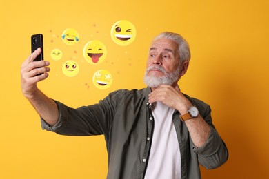 Image of Social media. Senior man taking selfie on orange background. Different and emojis near gadget