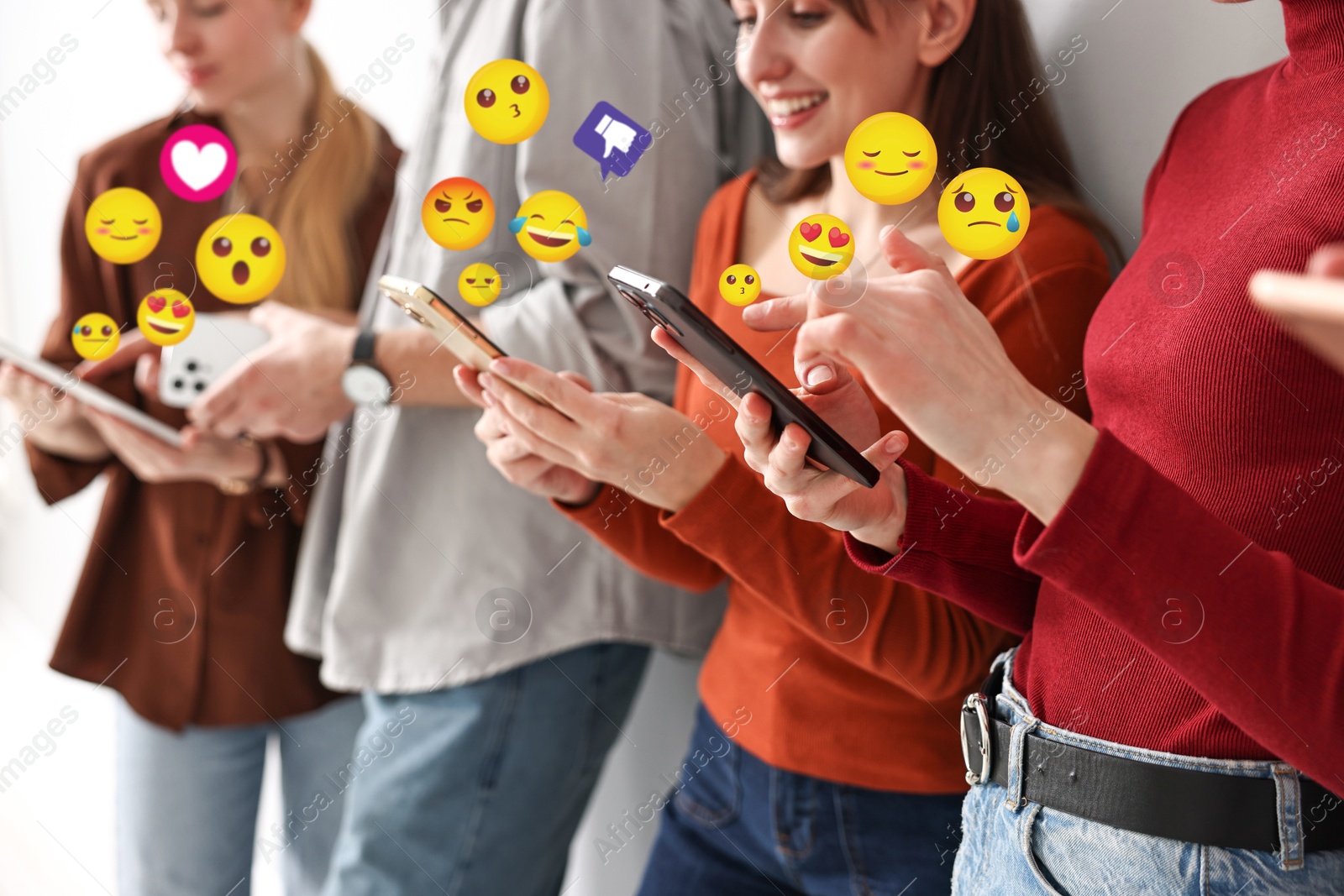 Image of Social media. Group of young people using different gadgets, closeup. Different notification signs and emojis near them