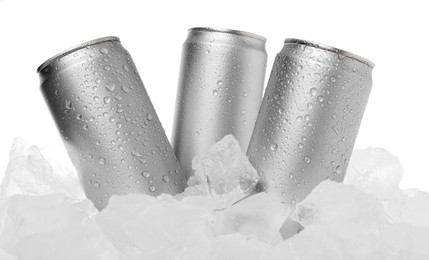 Photo of Refreshing drinks in cans on ice cubes against white background