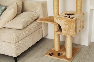 Photo of Stylish cat tree and sofa in living room
