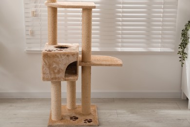 Photo of Stylish cat tree in living room, space for text