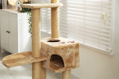Photo of Stylish cat tree and chest of drawers in living room