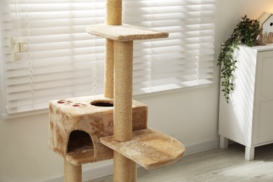 Photo of Stylish cat tree and chest of drawers in living room