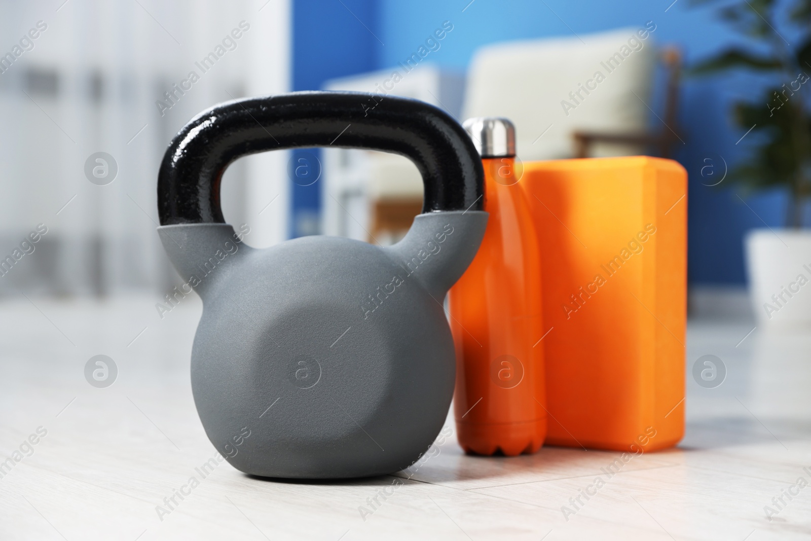 Kettlebell and other sports equipment on floor indoors Photo of Kettlebell and other sports equipment on floor indoors