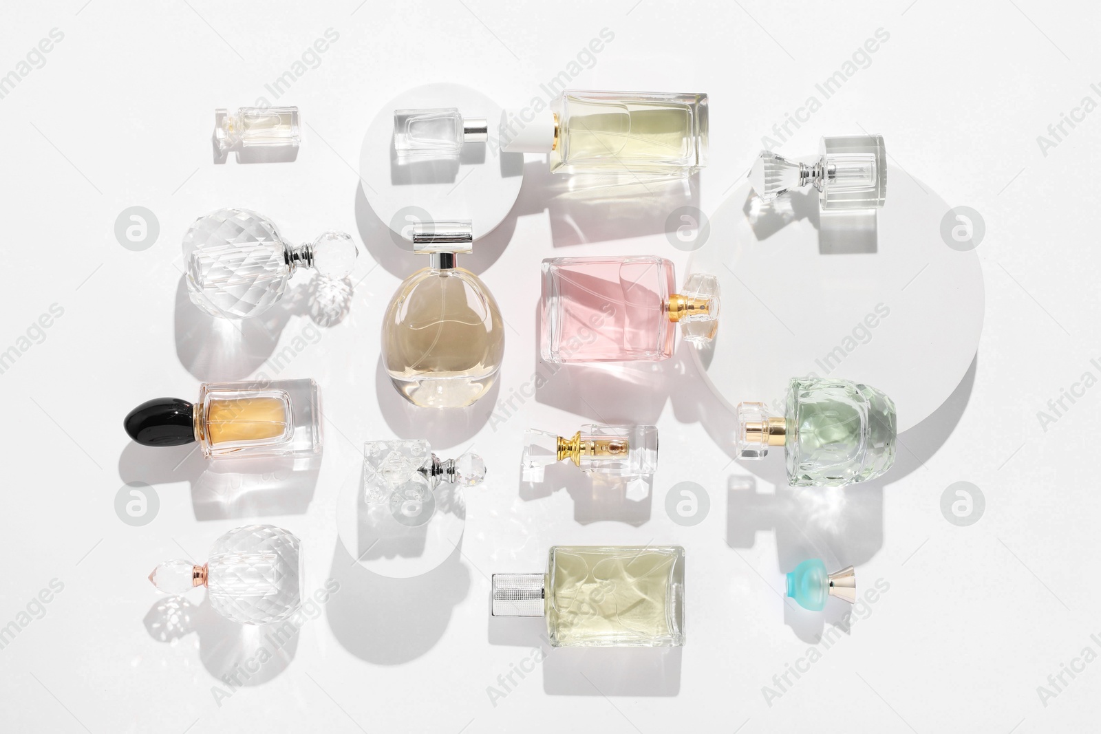 Different luxury perfumes on white background, flat lay Photo of Different luxury perfumes on white background, flat lay