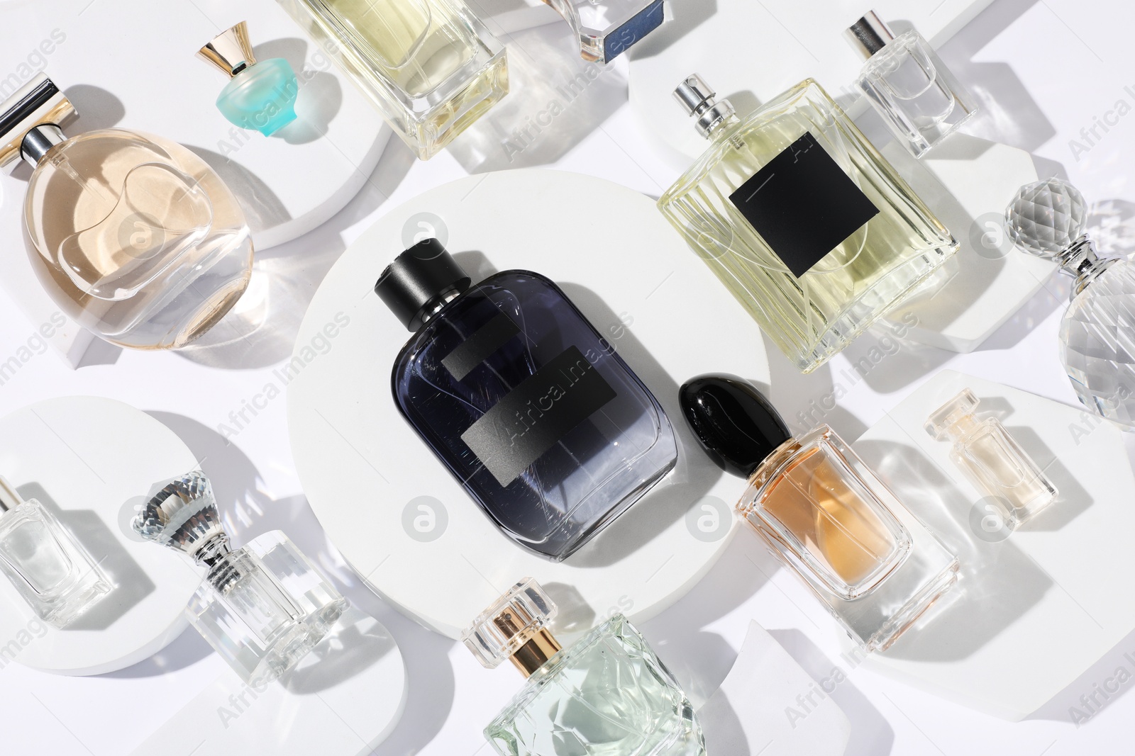 Different luxury perfumes on white background, flat lay Photo of Different luxury perfumes on white background, flat lay