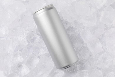 Photo of Refreshing drink in can on ice cubes, top view