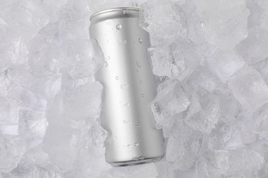 Photo of Refreshing drink in can on ice cubes, top view. Space for text