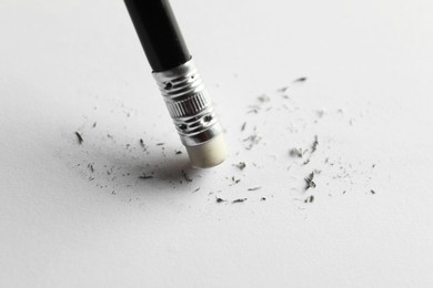 Photo of Using pencil with eraser on white sheet of paper, closeup