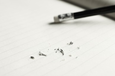 Photo of Pencil with eraser and scraps on copybook, selective focus