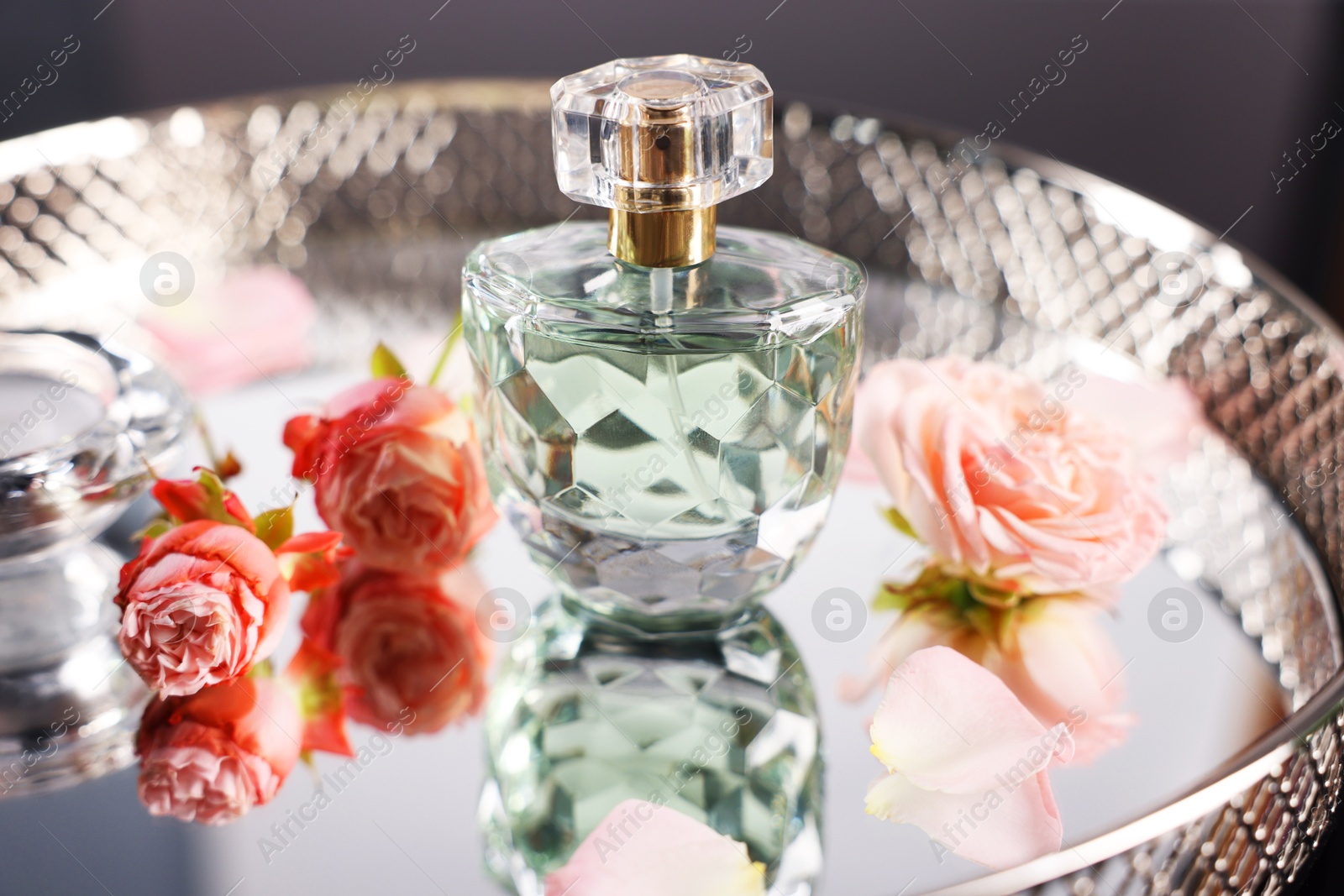 Bottle of aromatic perfume and flowers on metal tray, closeup Photo of Bottle of aromatic perfume and flowers on metal tray, closeup