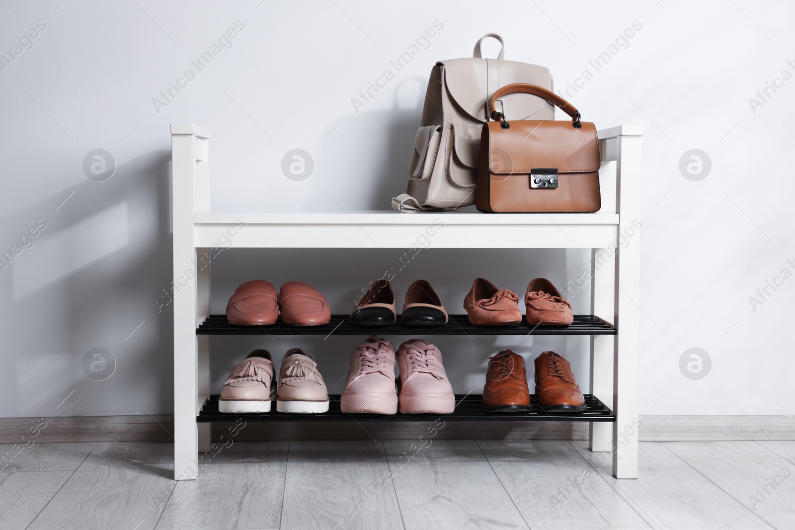 Stand with different stylish shoes and bags indoors Photo of Stand with different stylish shoes and bags indoors