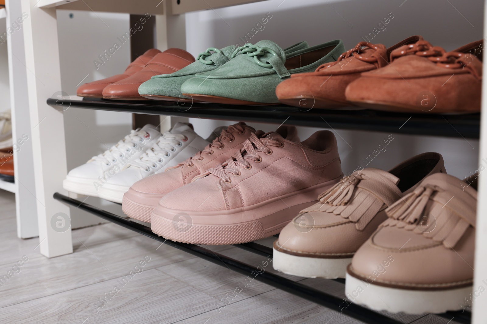Stand with different stylish shoes indoors, closeup Photo of Stand with different stylish shoes indoors, closeup