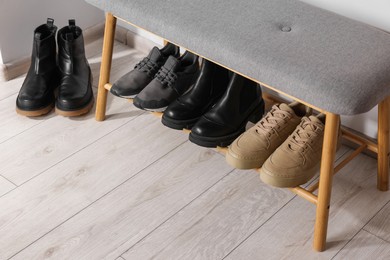 Photo of Stand with different stylish shoes indoors. Space for text