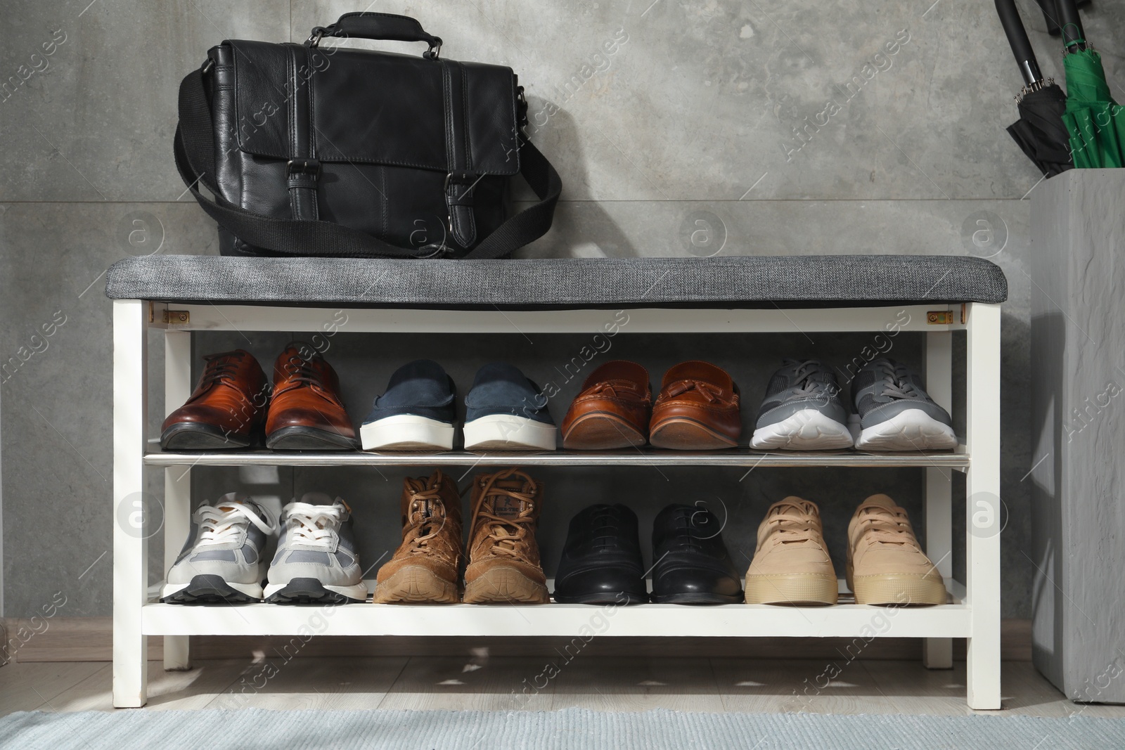 Shoe storage bench with different footwear and briefcase indoors Photo of Shoe storage bench with different footwear and briefcase indoors
