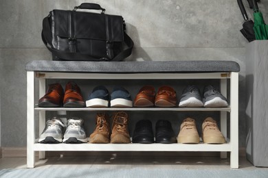 Photo of Shoe storage bench with different footwear and briefcase indoors