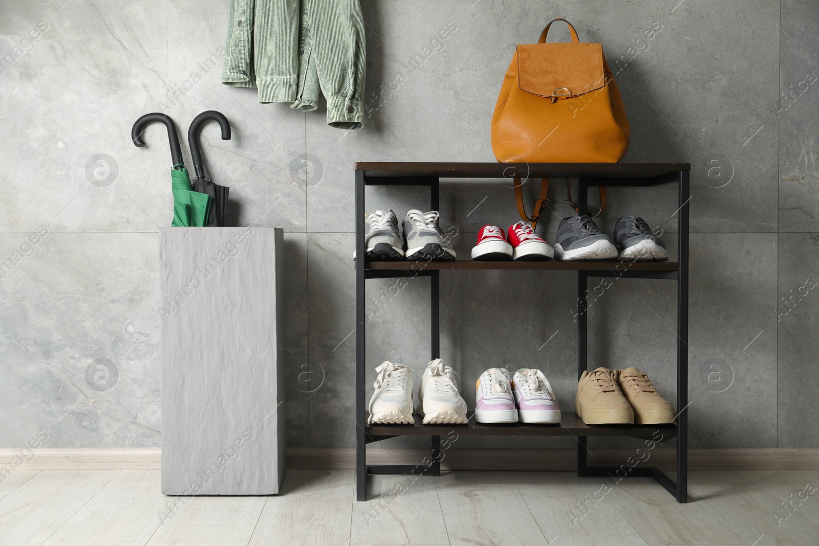 Shoe storage. Shelving unit with different footwear, backpack and umbrellas indoors Photo of Shoe storage. Shelving unit with different footwear, backpack and umbrellas indoors