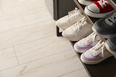 Photo of Shoe storage. Shelving unit with different footwear indoors, closeup. Space for text