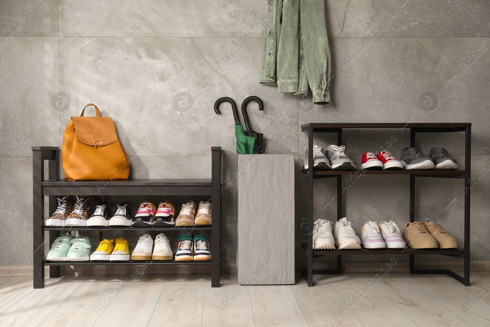 Shoe storage. Shelving units with different footwear, backpack and umbrellas indoors Photo of Shoe storage. Shelving units with different footwear, backpack and umbrellas indoors