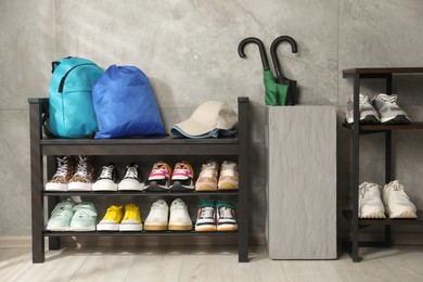 Photo of Shoe storage bench with different footwear and other accessories indoors