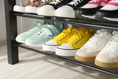 Photo of Shoe storage bench with different footwear indoors, closeup