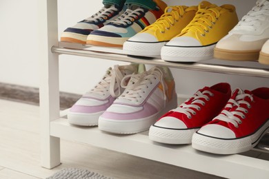 Photo of Shoe storage bench with different footwear indoors, closeup