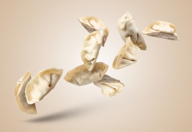 Image of Uncooked gyoza falling on dark beige background