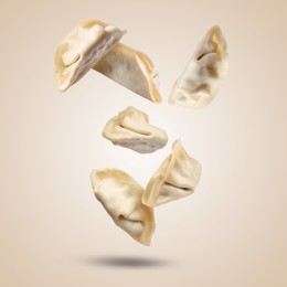 Image of Uncooked gyoza falling on dark beige background
