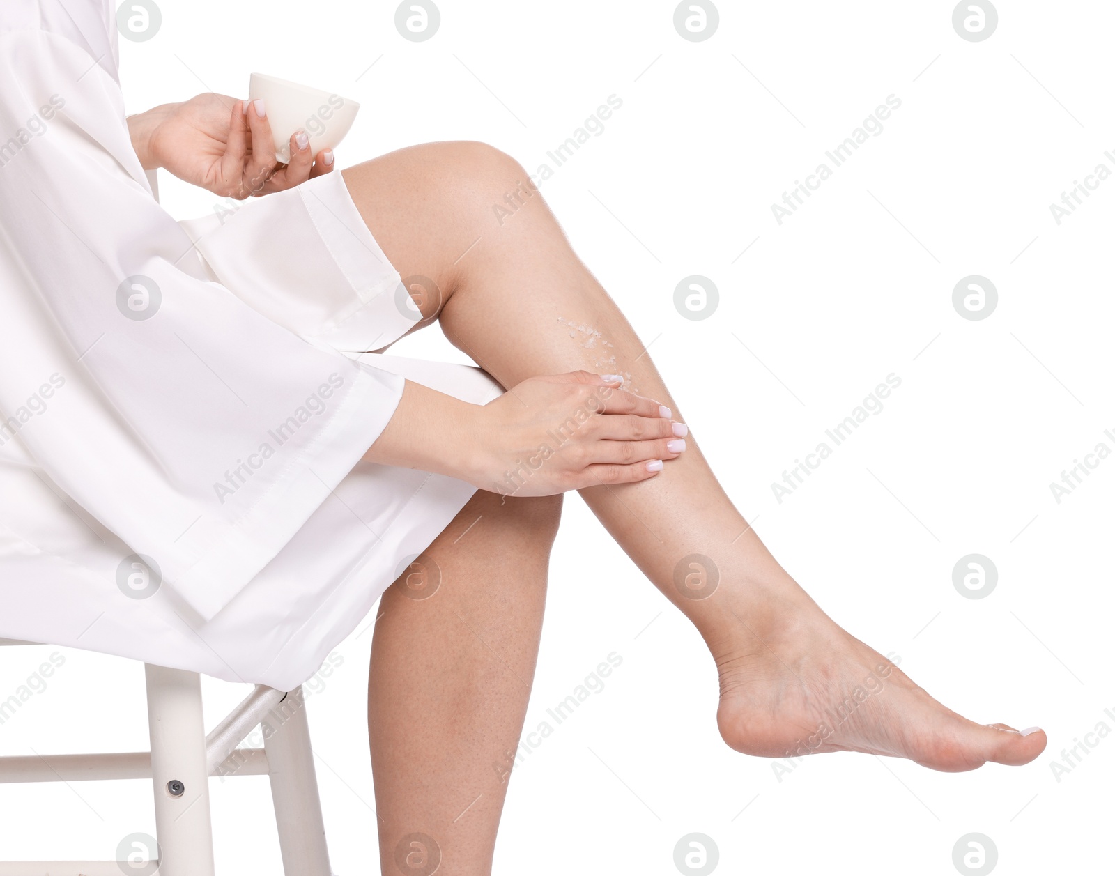Woman applying body scrub onto her leg on white background, closeup Photo of Woman applying body scrub onto her leg on white background, closeup