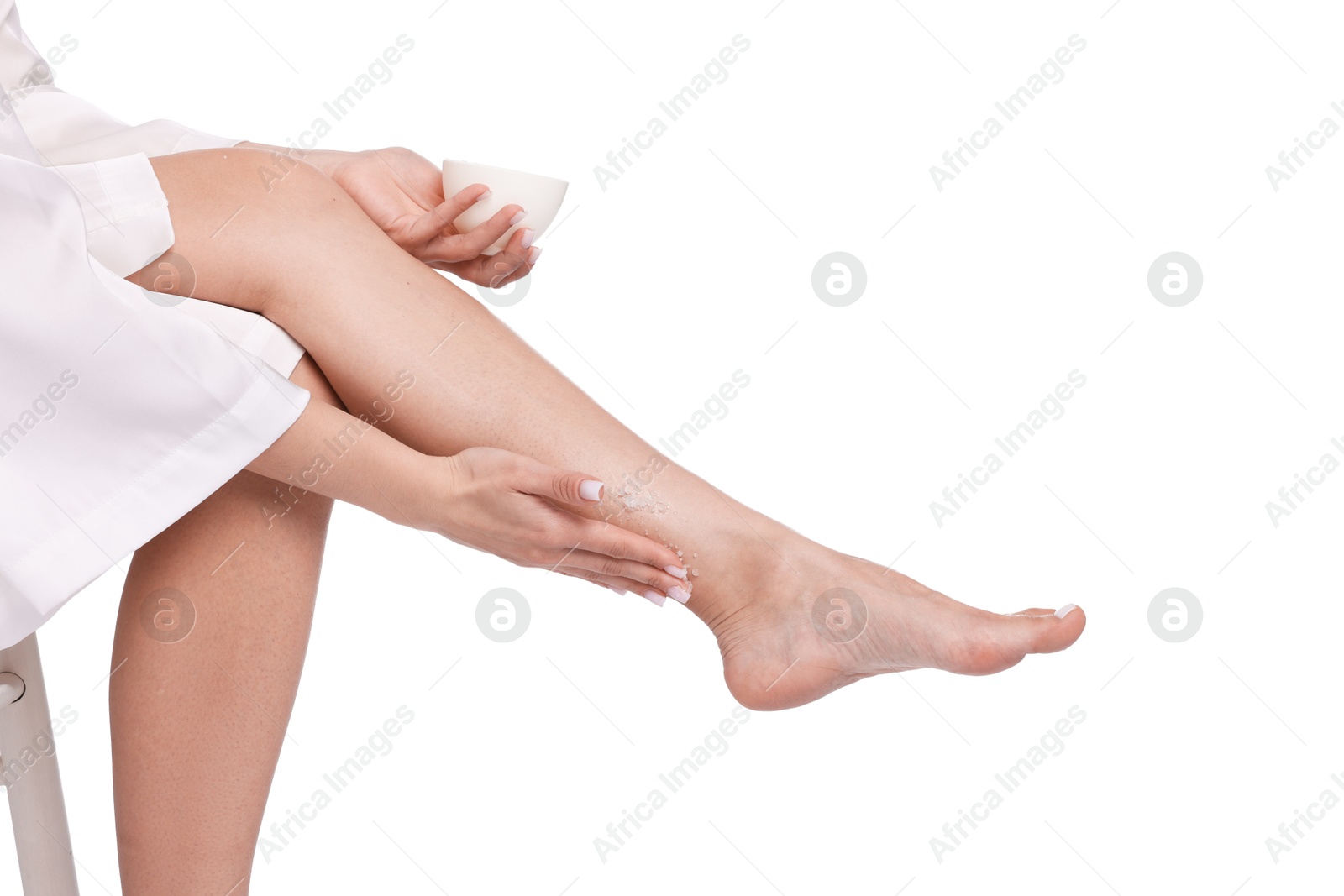 Woman applying body scrub onto her leg on white background, closeup Photo of Woman applying body scrub onto her leg on white background, closeup