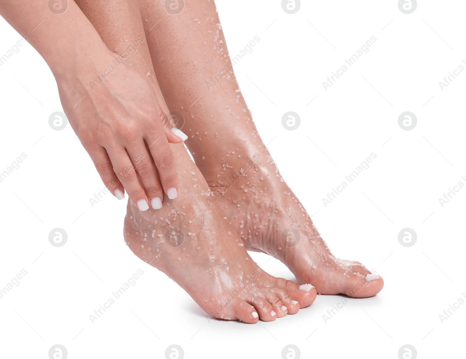 Woman applying body scrub onto her feet on white background, closeup Photo of Woman applying body scrub onto her feet on white background, closeup