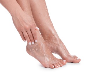 Photo of Woman applying body scrub onto her feet on white background, closeup