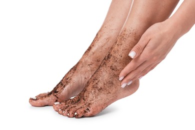 Photo of Woman applying body scrub onto her feet on white background, closeup
