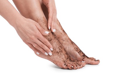 Photo of Woman applying body scrub onto her feet on white background, closeup