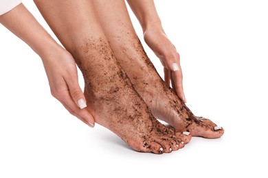 Photo of Woman applying body scrub onto her feet on white background, closeup