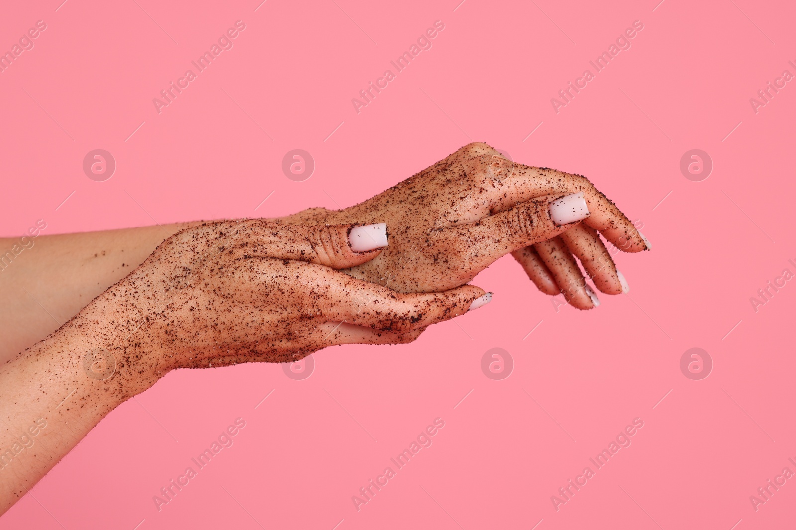 Woman applying body scrub onto her hands on pink background, closeup Photo of Woman applying body scrub onto her hands on pink background, closeup