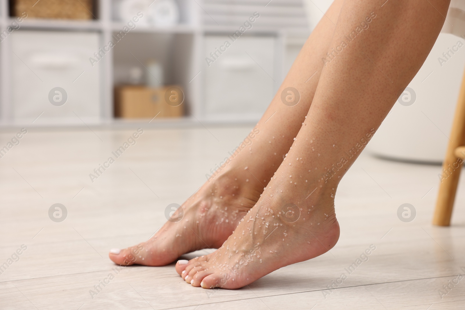Woman with body scrub on her feet indoors, closeup Photo of Woman with body scrub on her feet indoors, closeup